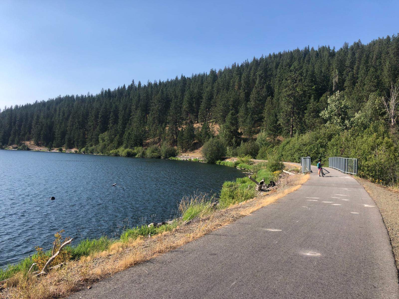 Single rider on the Trail of the Coeur d'Alenes with lake views